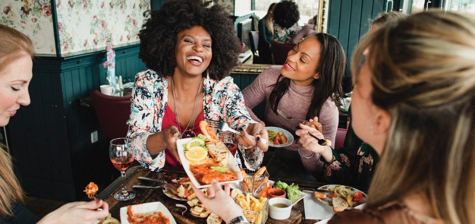 A group of women enjoy food and drinks on Restaurant Row in Orlando, Florida.