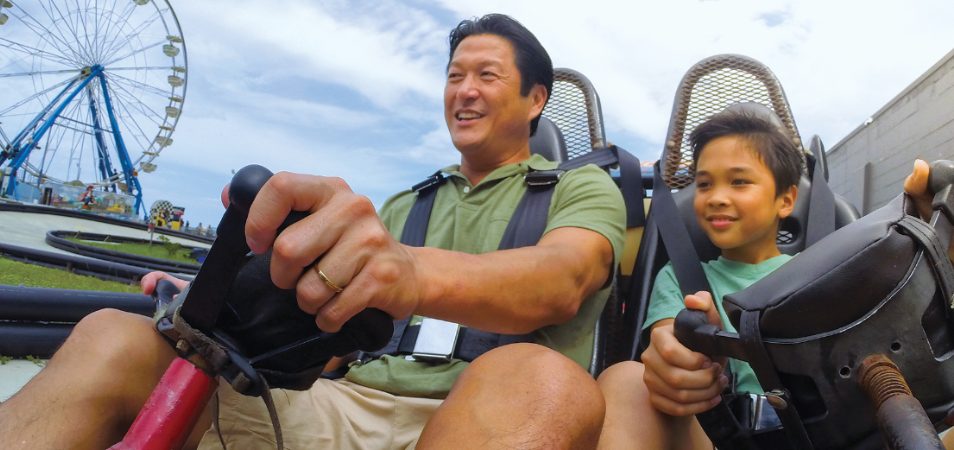 A dad and son ride in a go-kart on I-Drive in Orlando, Florida.