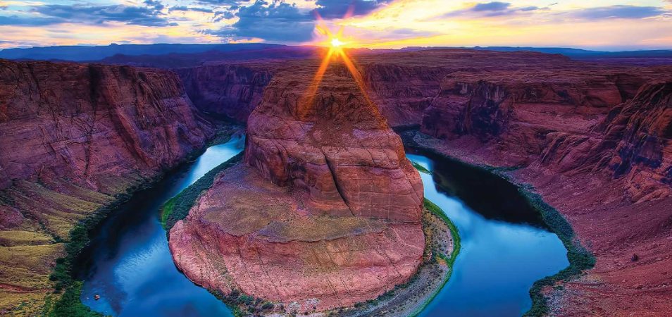 A river winding around red rock mountains at Glen Canyon National Recreation Area.