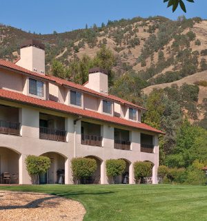 The exterior of a resort in front of a small mountain range at WorldMark Clear Lake.