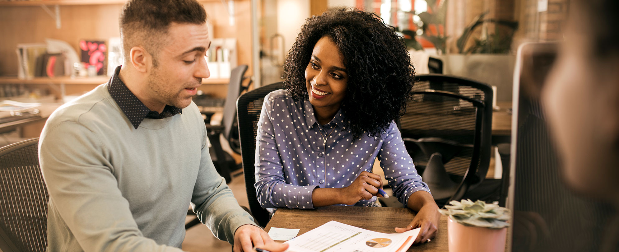 A man from contact title services going over paperwork with a woman. 