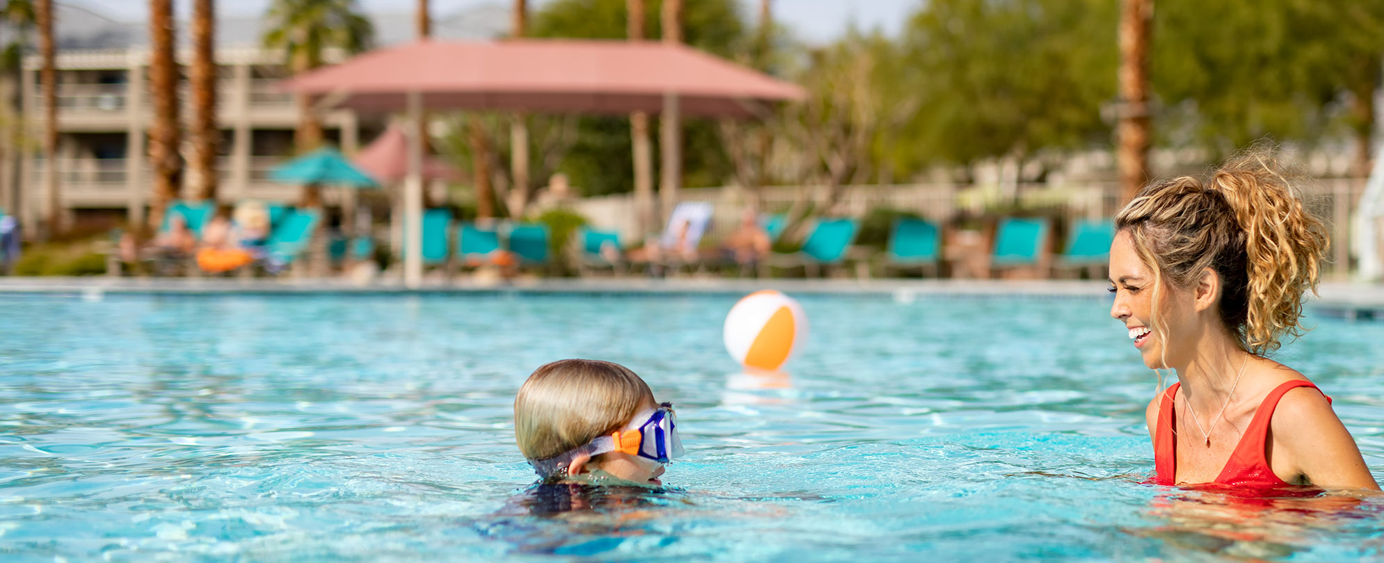 A mother and her child swim in a Worldmark by Wyndham resort pool.