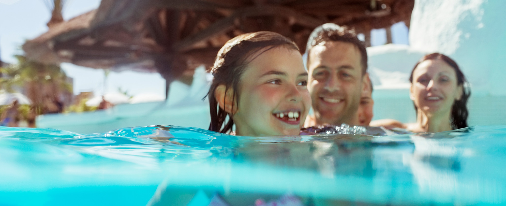 Close-up of a family of four swimming in a pool at an island-themed resort in Las Vegas, Nevada.