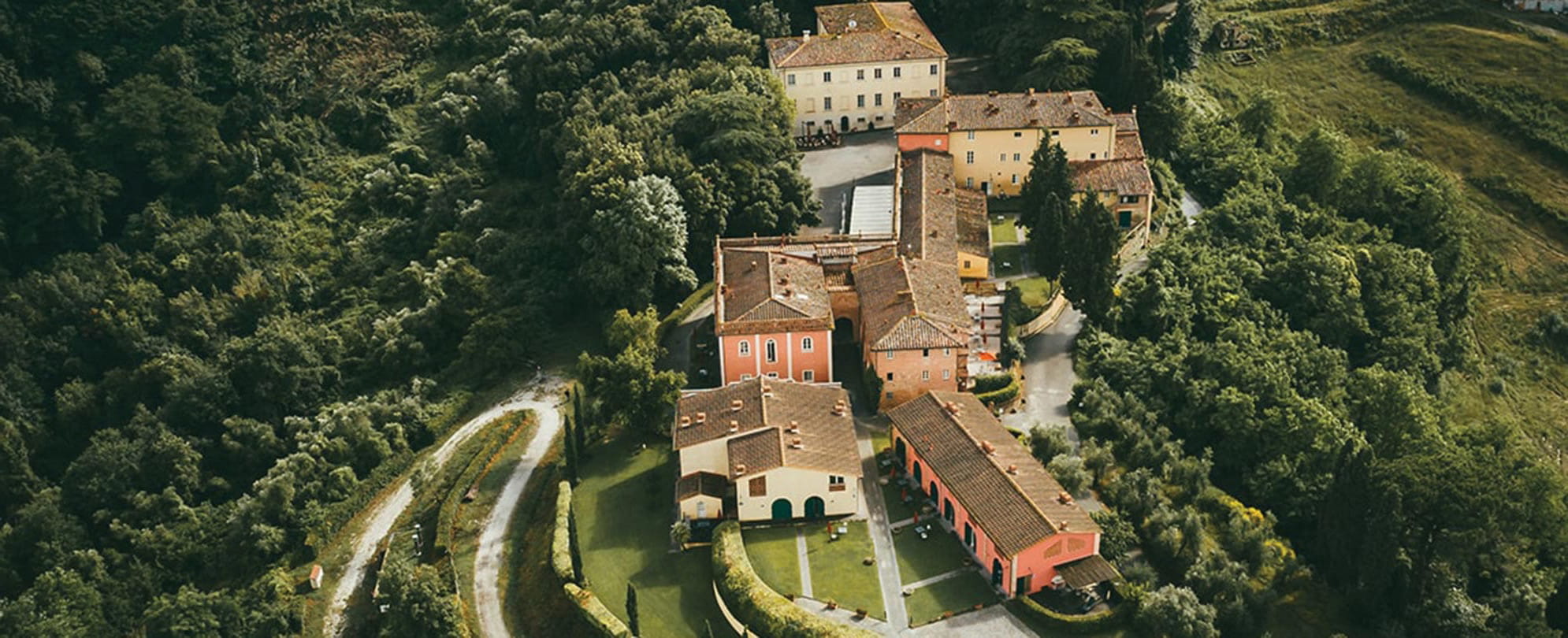 A birds-eye-view of buildings in Europe surrounded by dark green forrest. 